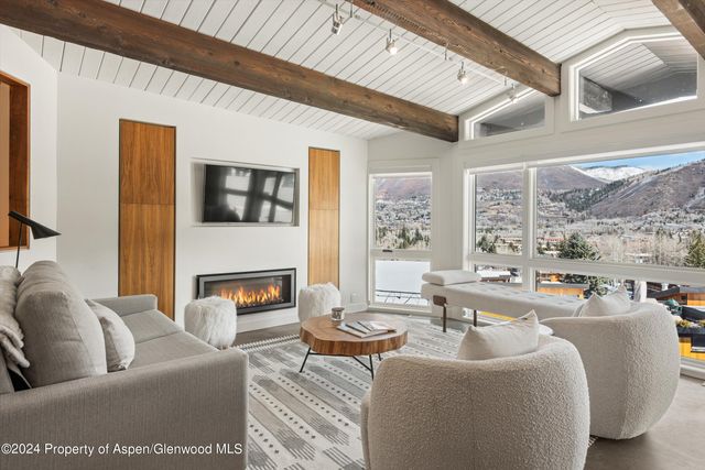 a living room with fireplace furniture and a large window