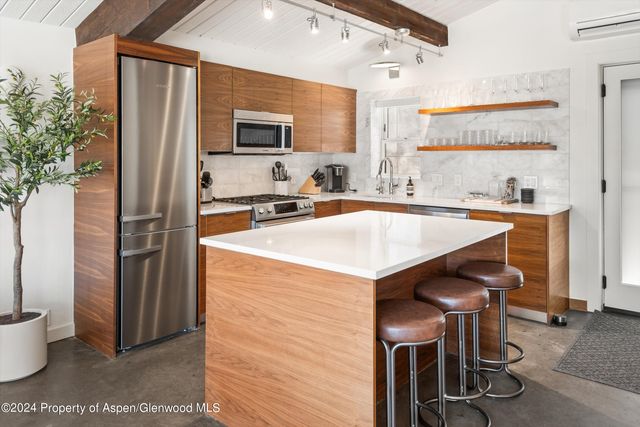 a kitchen with a table chairs refrigerator and microwave