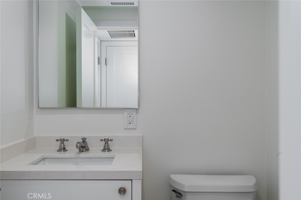480 Morning Canyon Road Corona del Mar, CA 92625 - Photo 19 of 33 a bathroom with a toilet sink and mirror