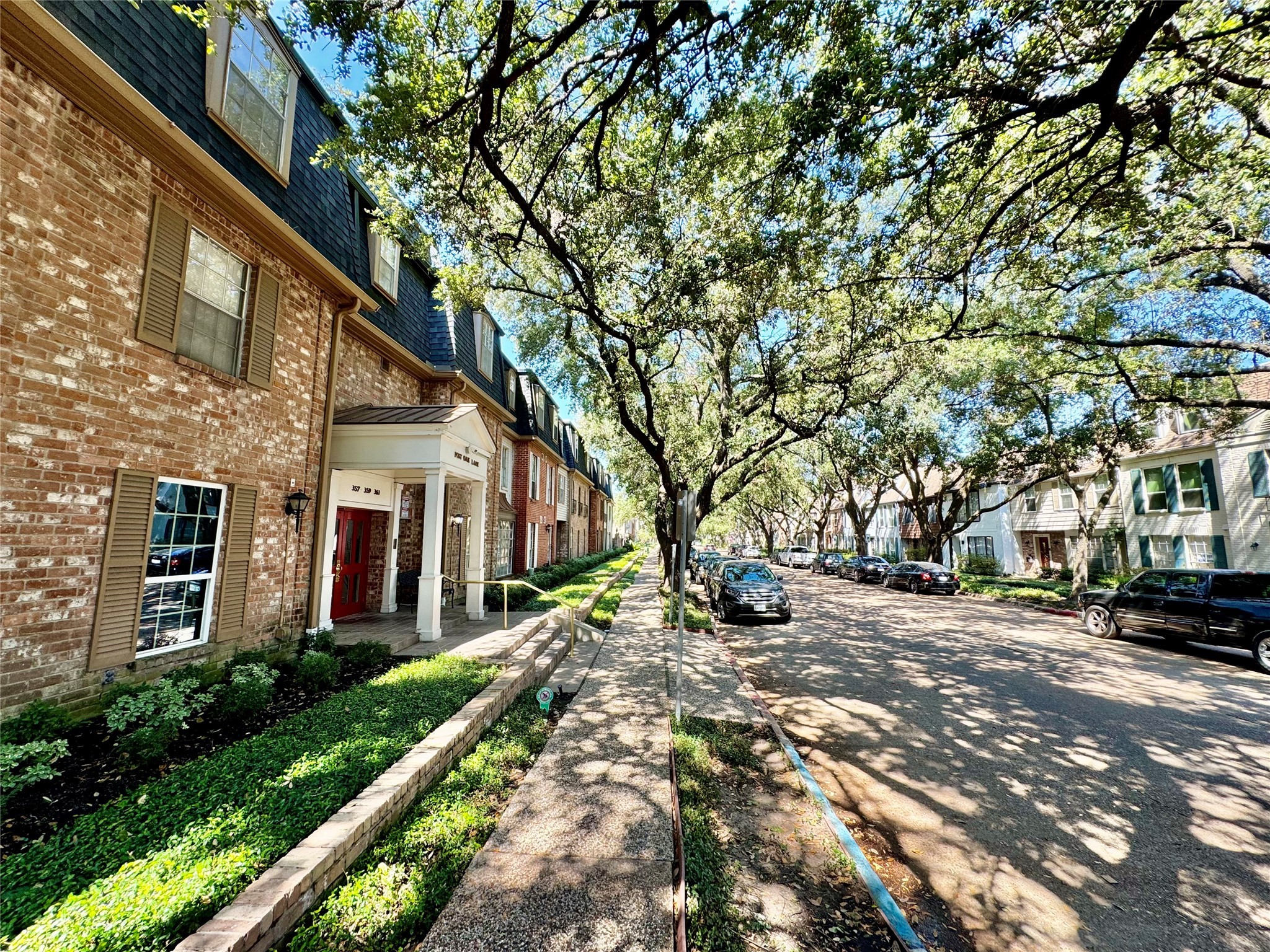 357 North Post Oak Lane, Unit 209 Houston, TX 77024 - Photo 20 of 20 a wooden bench sitting in front of a building