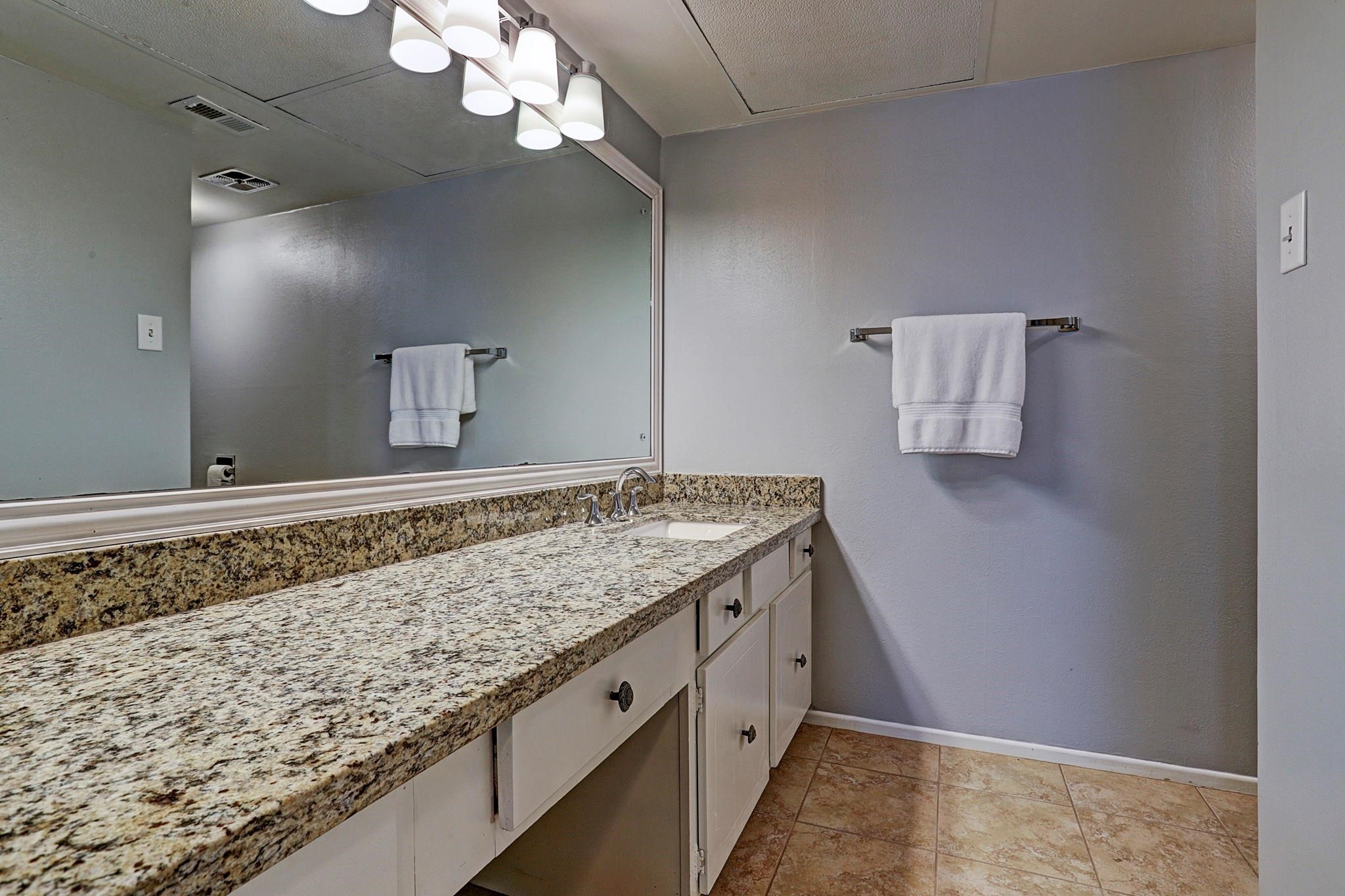 357 North Post Oak Lane, Unit 209 Houston, TX 77024 - Photo 10 of 20 a bathroom with a granite countertop sink and a mirror