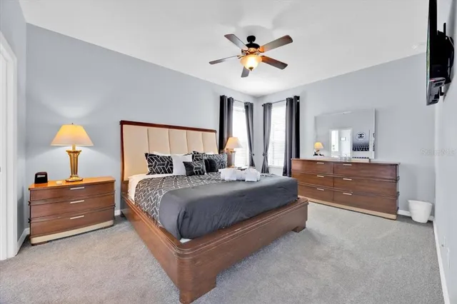 a spacious bedroom with a bed and a chandelier