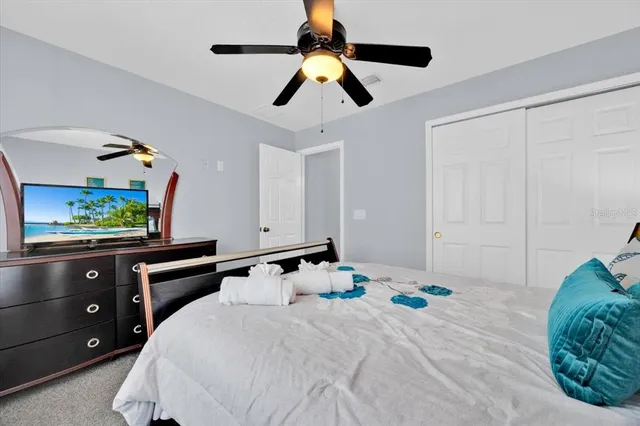 a bedroom with a bed and a flat tv screen on dresser