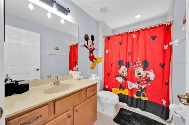 a bathroom with a sink vanity mirror and toilet