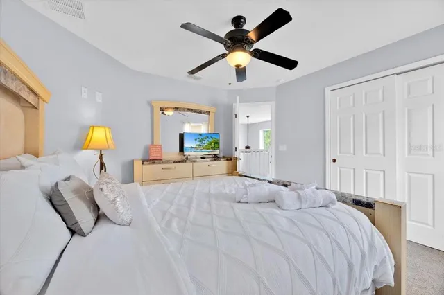 a bedroom with a large bed and a chandelier