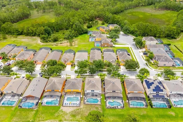 an aerial view of residential houses with outdoor space and swimming pool