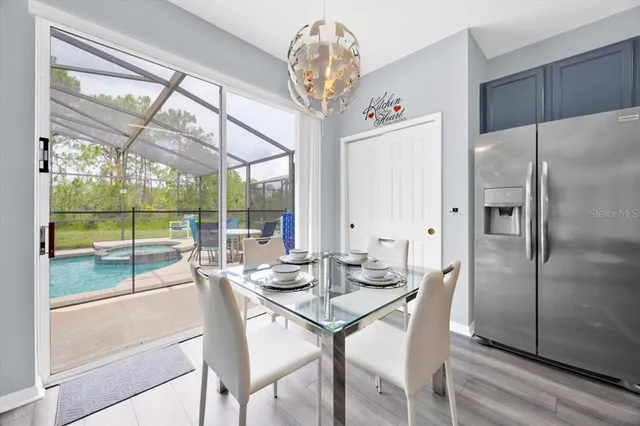 a dining room with furniture a chandelier and wooden floor