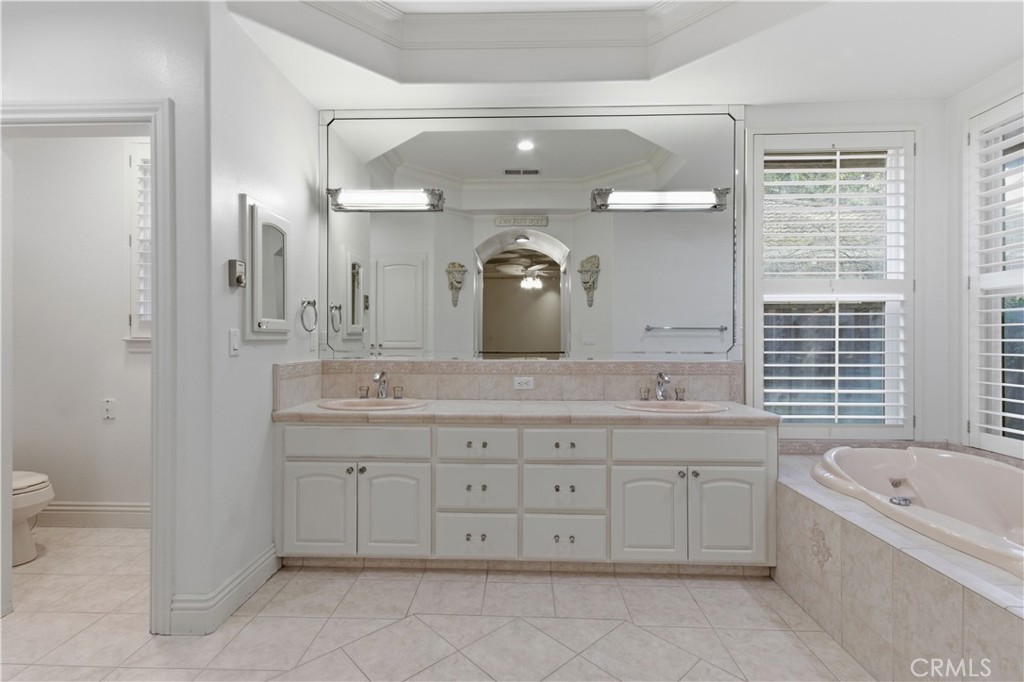 2144 King Arthur Court Merced, CA 95340 - Photo 43 of 66 a bathroom with a granite countertop double vanity sink a mirror and a bathtub