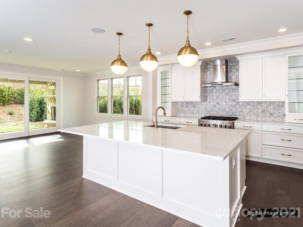 12031 Huntson Reserve Road Huntersville, NC 28078 - Photo 7 of 23 a large kitchen with kitchen island a large window a sink and cabinets