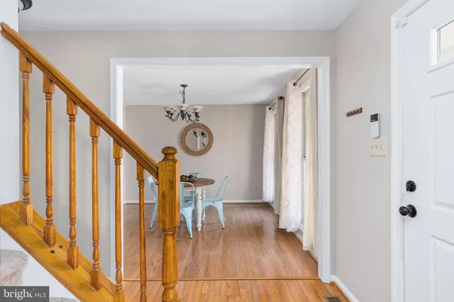 a dining room with furniture a chandelier and wooden floor