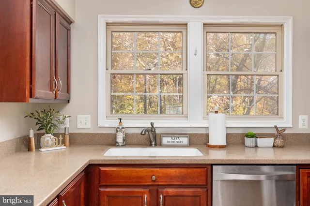 a kitchen with stainless steel appliances granite countertop a stove a sink dishwasher a refrigerator and a microwave oven with wooden floor