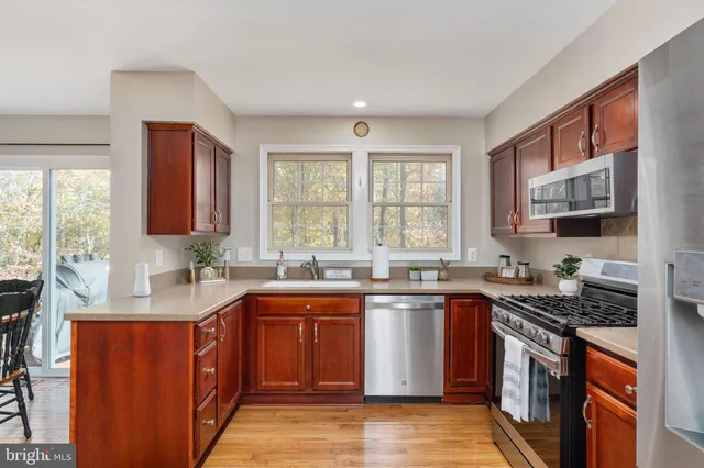 a view of a kitchen with refrigerator and wooden floor