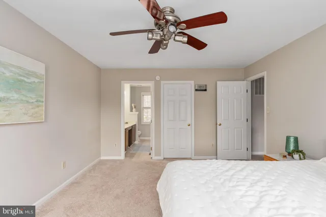 an empty room with chandelier fan and windows