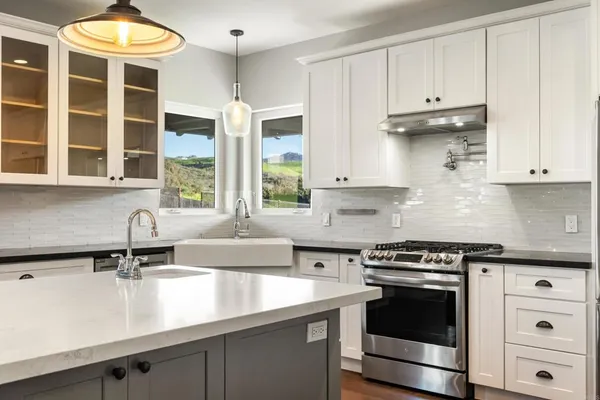 a kitchen with stainless steel appliances granite countertop a sink and a stove
