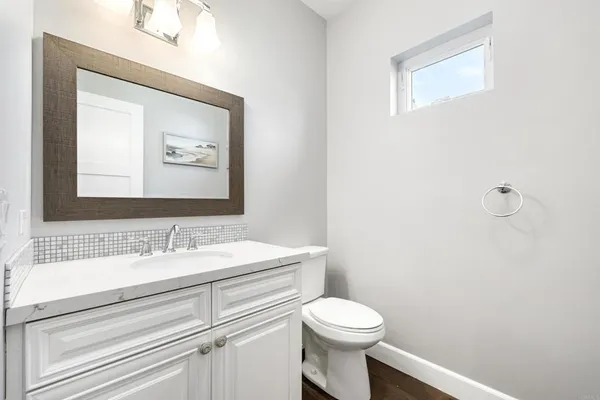 a bathroom with a toilet sink and mirror