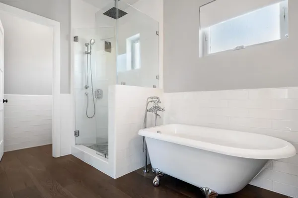 a bathroom with a white tub shower and sink