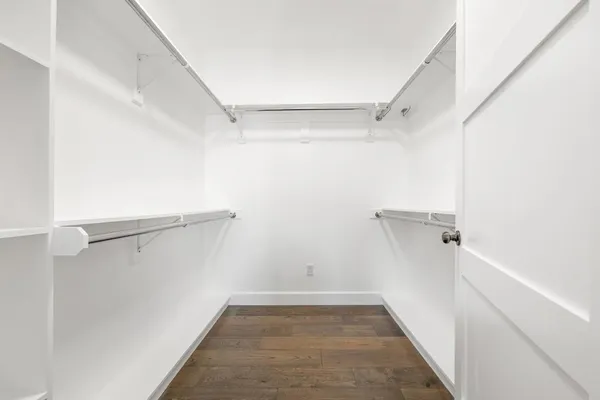 a view of walk in closet with empty racks