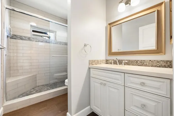 a bathroom with a shower sink and mirror