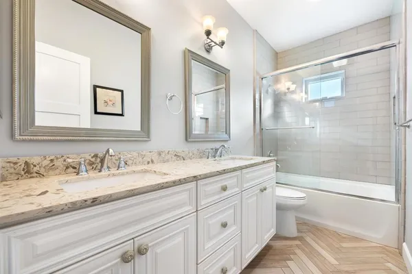 a bathroom with a granite countertop sink a toilet and a bathtub