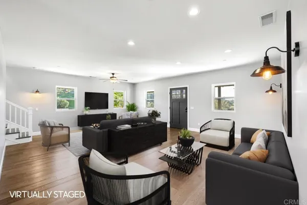 a living room with furniture a flat screen tv and kitchen view