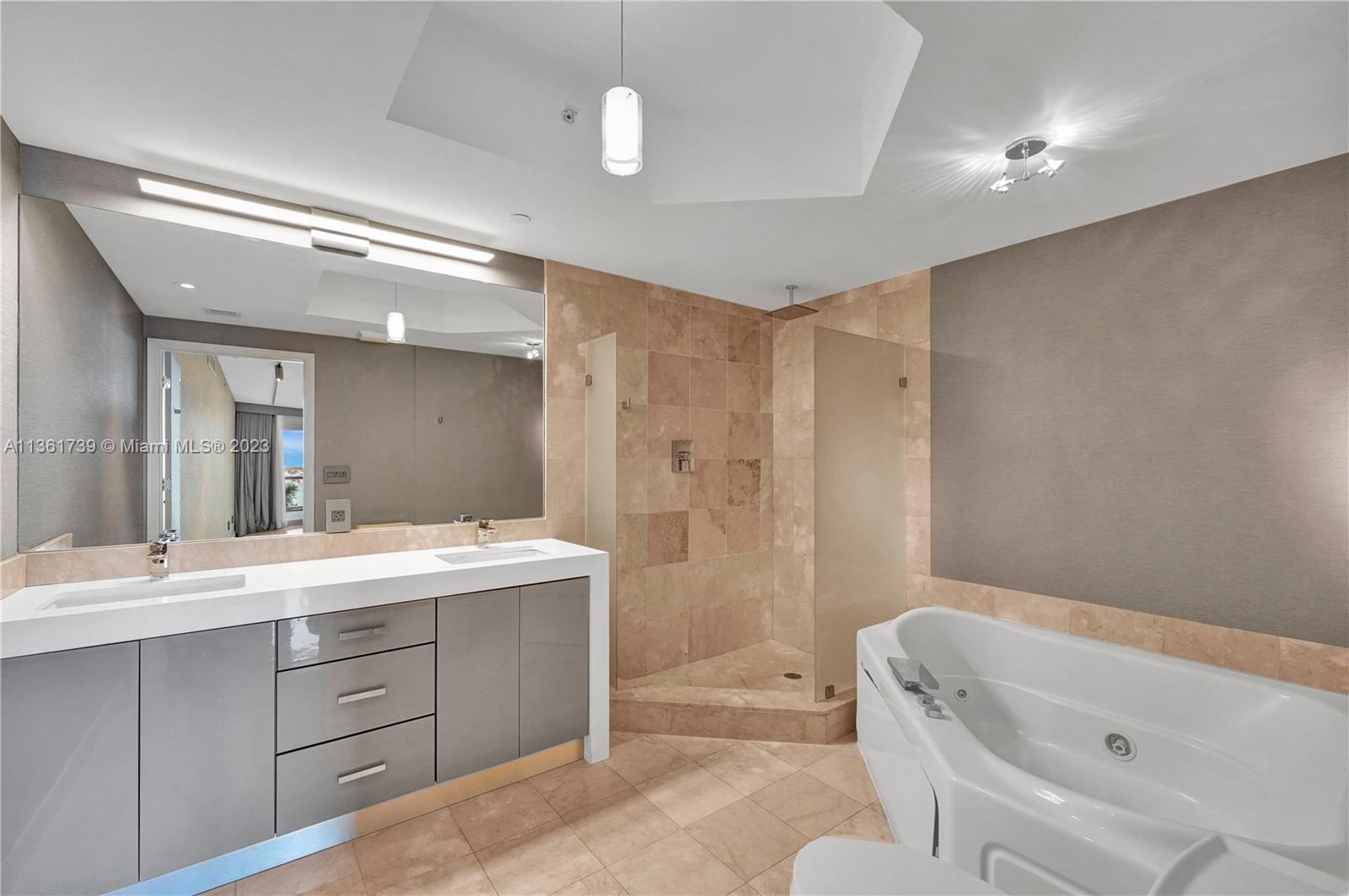 10 Venetian Way, Unit 603 Miami Beach, FL 33139 - Photo 14 of 30 a bathroom with a tub sink and mirror