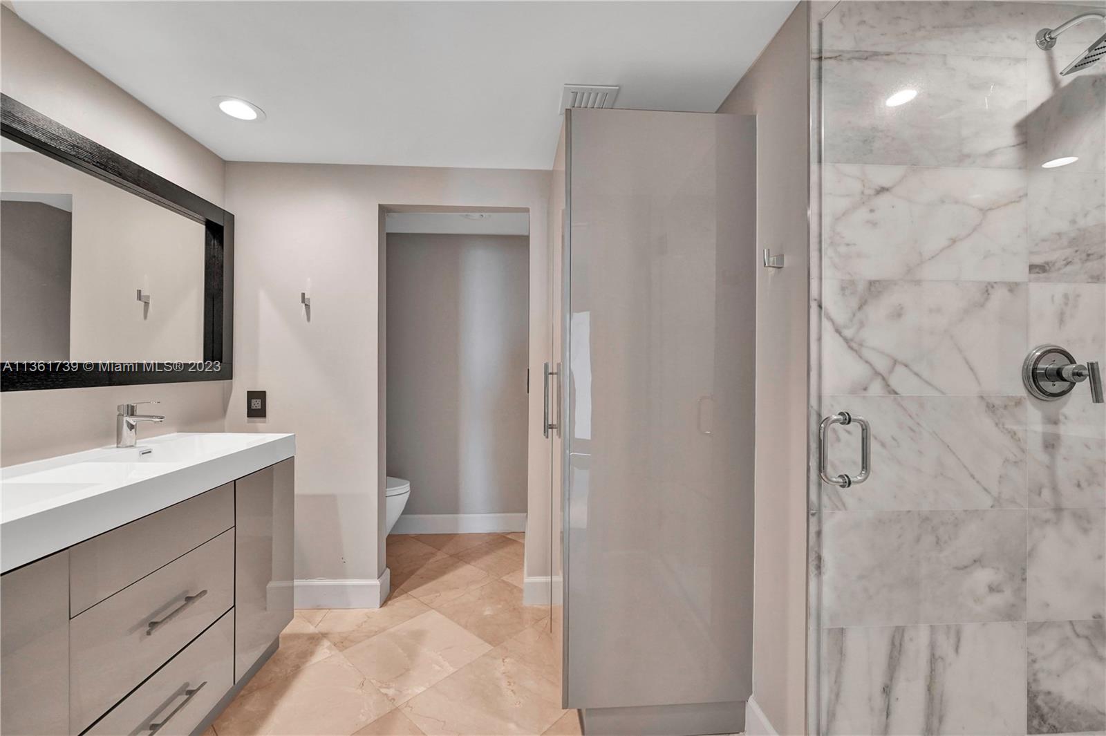 10 Venetian Way, Unit 603 Miami Beach, FL 33139 - Photo 19 of 30 a bathroom with a double vanity sink mirror and shower