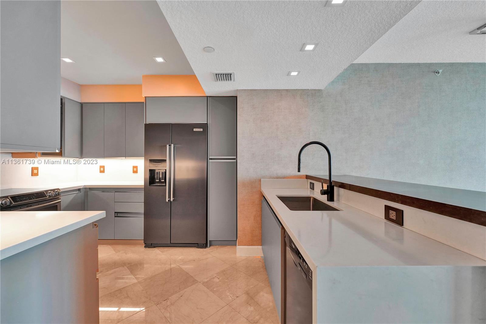 10 Venetian Way, Unit 603 Miami Beach, FL 33139 - Photo 8 of 30 a kitchen with stainless steel appliances a sink a counter top space cabinets and a window