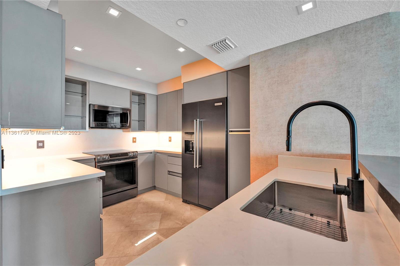 10 Venetian Way, Unit 603 Miami Beach, FL 33139 - Photo 9 of 30 a kitchen with stainless steel appliances kitchen island granite countertop a stove a refrigerator and a sink