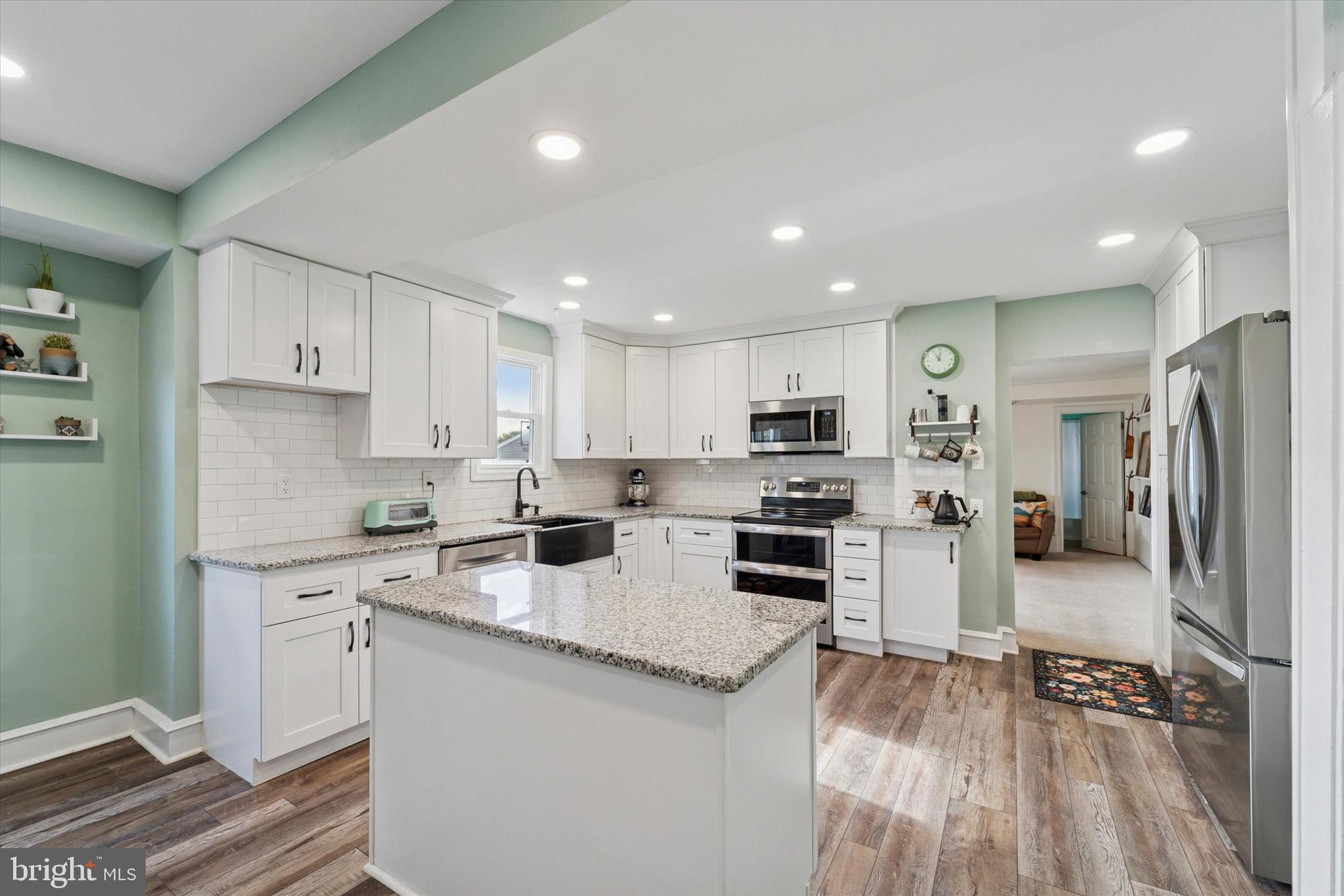 339 Sutton Avenue Folsom, PA 19033 - Photo 7 of 26 a kitchen with white cabinets and stainless steel appliances