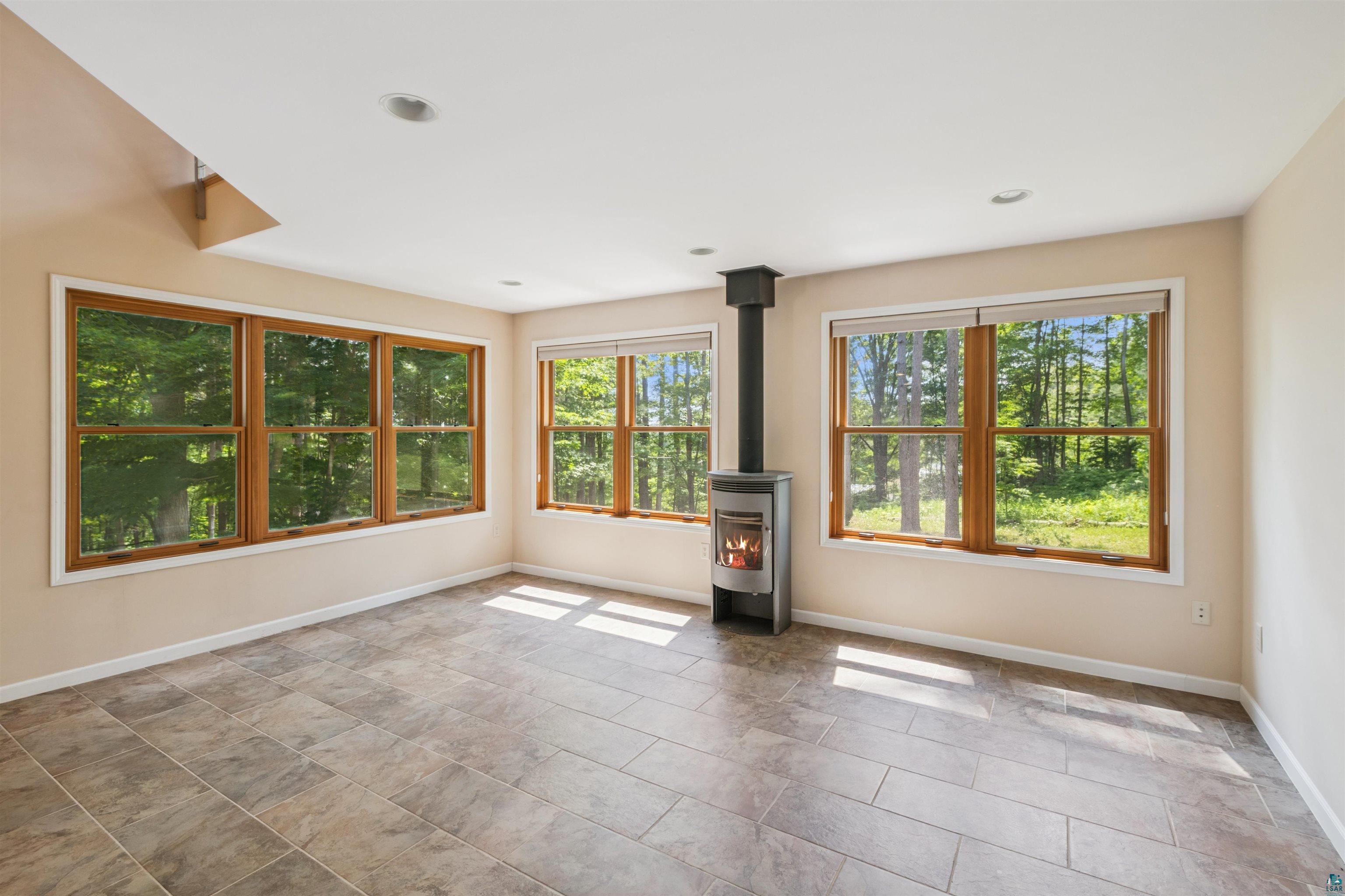 720 Rice Avenue Bayfield, WI 54814 - Photo 11 of 47 Empty room featuring a wood stove and recessed lighting