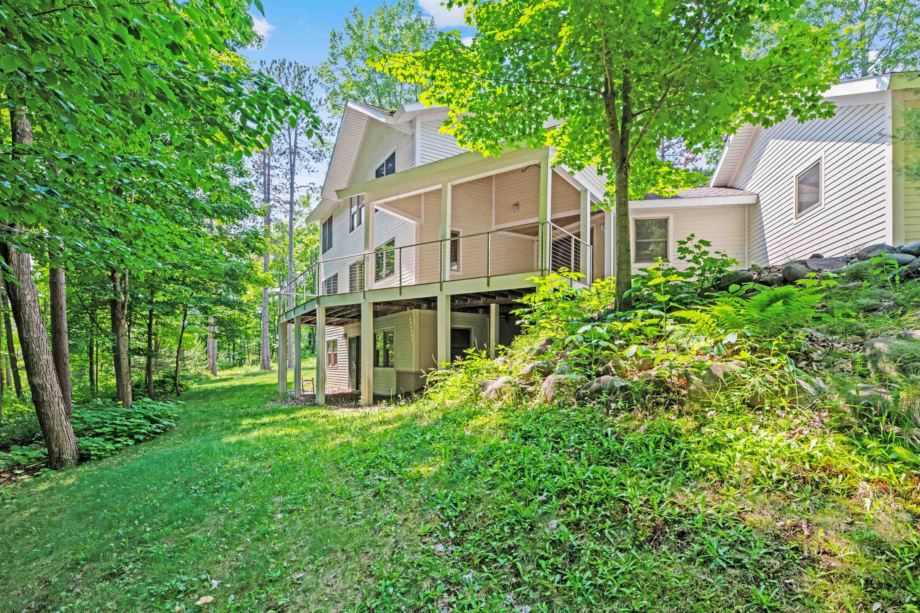 720 Rice Avenue Bayfield, WI 54814 - Photo 8 of 47 Rear view of property featuring a yard and a sunroom