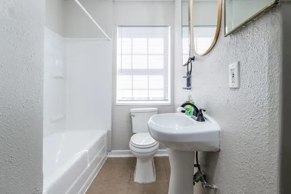 a bathroom with a sink a toilet and bathtub