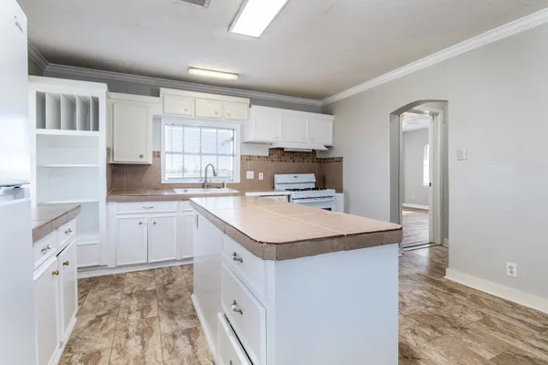 a kitchen with a sink window and cabinets