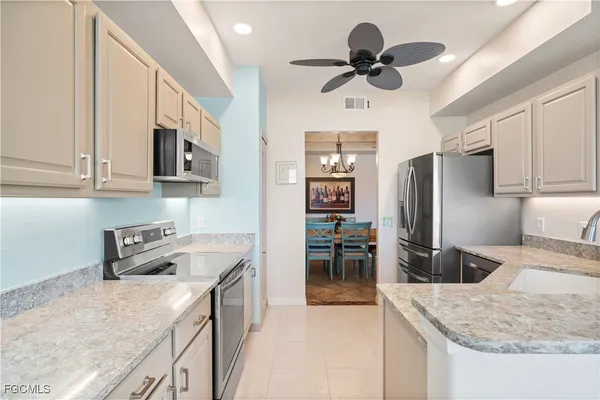 a kitchen with stainless steel appliances granite countertop a sink refrigerator and microwave