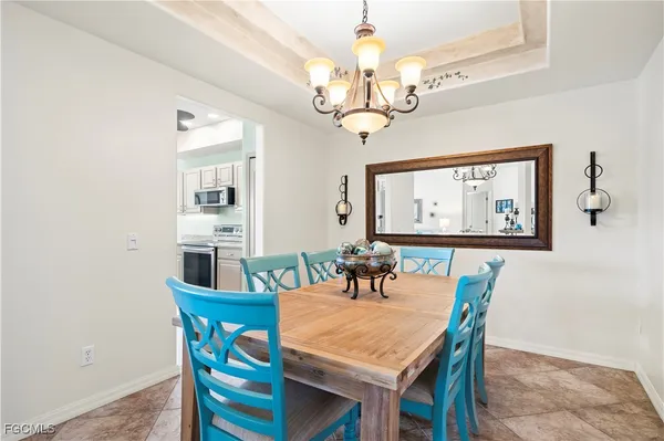 a view of a dining room with furniture a chandelier and wooden floor