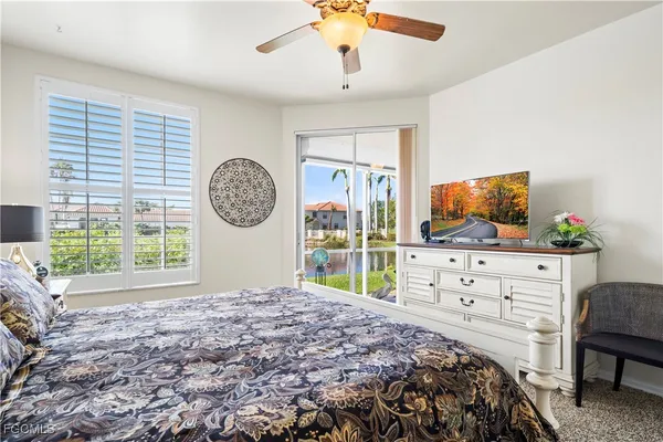 a bedroom with a bed a dresser and flat screen tv