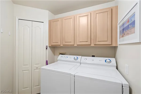 a view of washer and dryer with white cabinet
