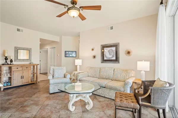 a living room with furniture and a dining table with lamp