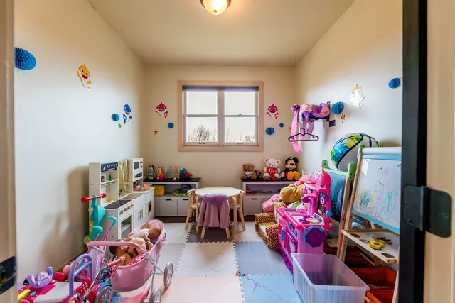 a bedroom with a large bed chandelier and a window