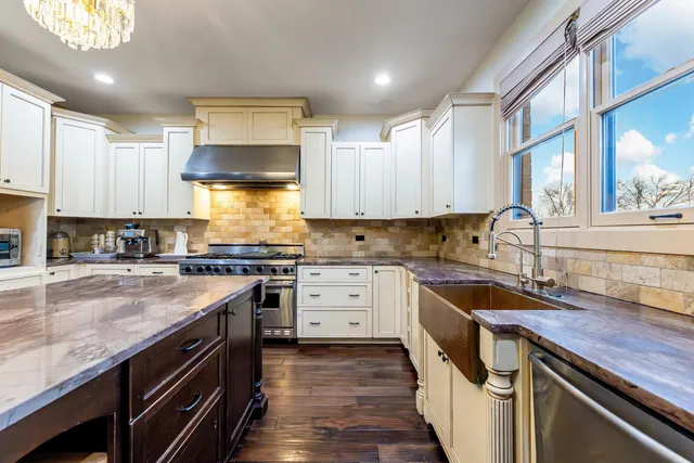 a kitchen with granite countertop a sink stove and cabinets