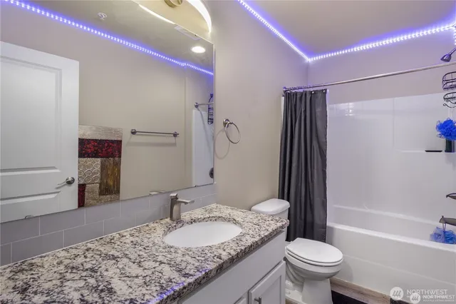a bathroom with a granite countertop sink toilet and shower