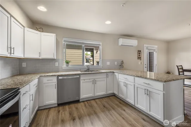 a kitchen with granite countertop white cabinets and white appliances