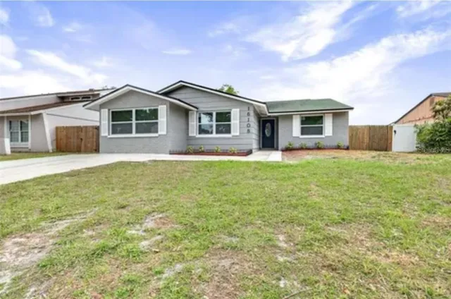 a front view of house with yard and trees around