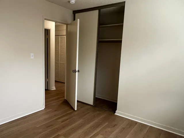 an empty room with wooden floor and closet