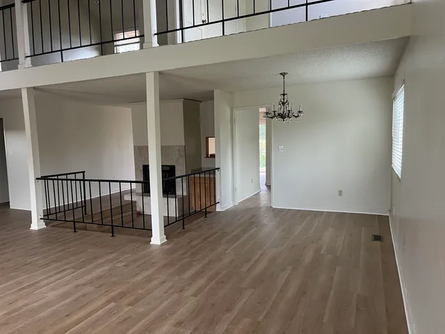a view of a hallway with wooden floor and staircase