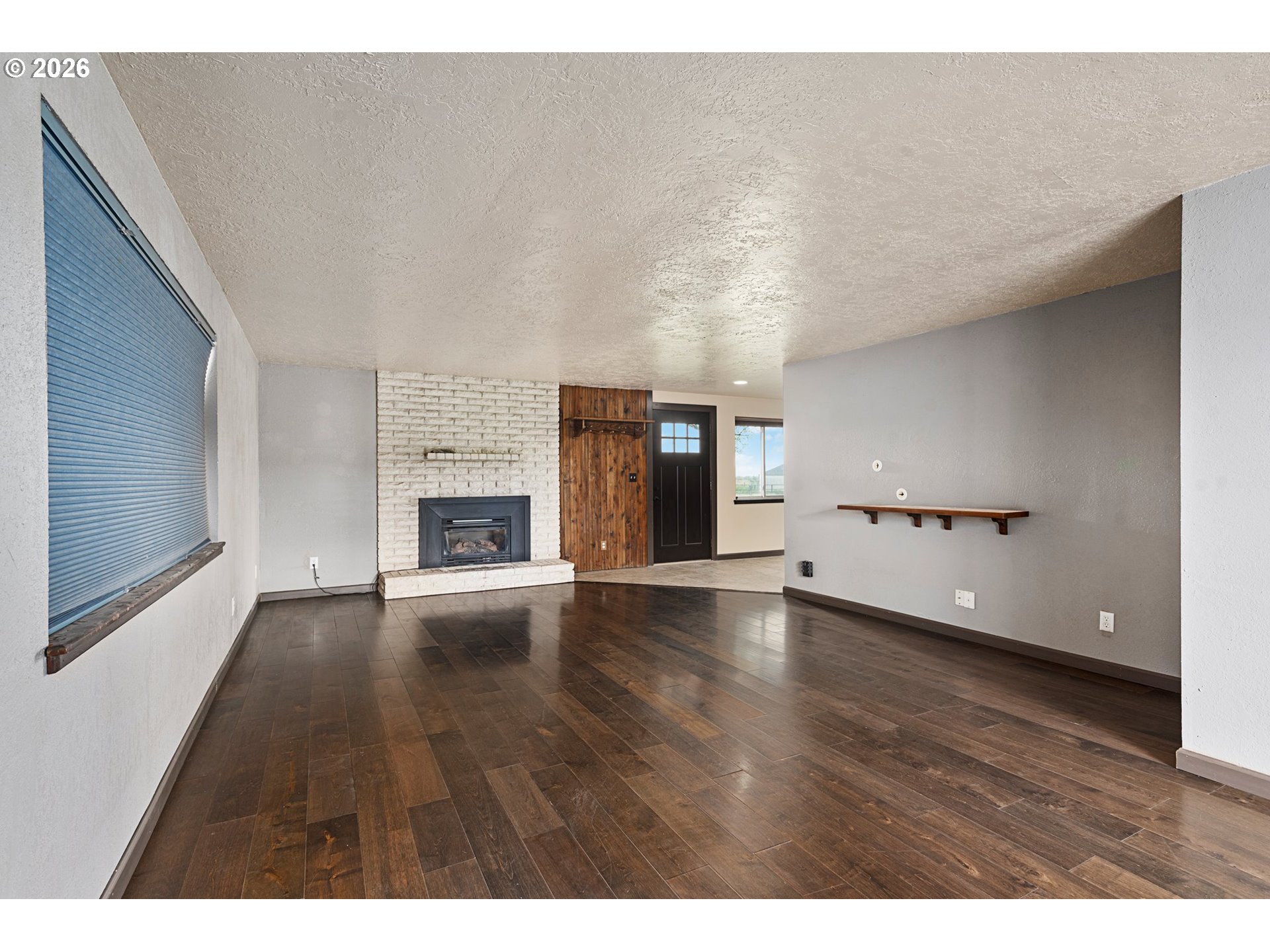 58015 Godley Road Union, OR 97883 - Photo 12 of 44 a view of empty room with wooden floor and fireplace