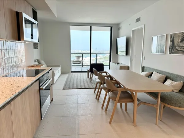 a dining room with furniture and large windows