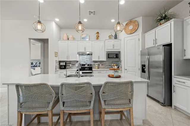 a kitchen with stainless steel appliances granite countertop a sink a stove and a refrigerator