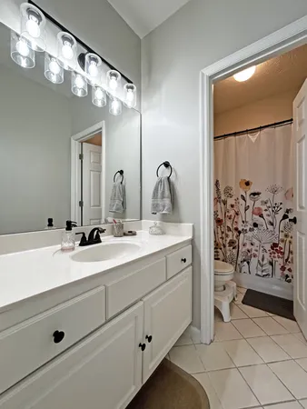 a bathroom with a double vanity sink mirror and shower