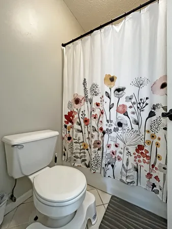 a white toilet sitting next to a shower curtain